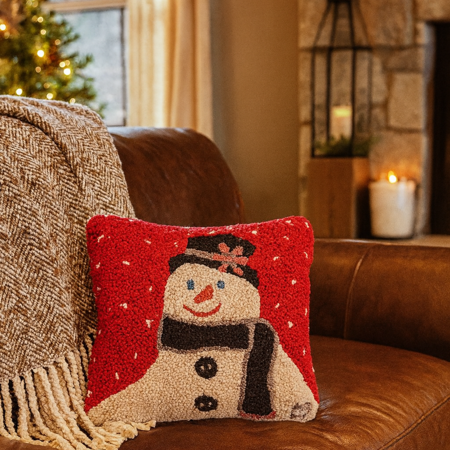 Decorative pillow with a snowman design on a brown couch in a cozy living room.